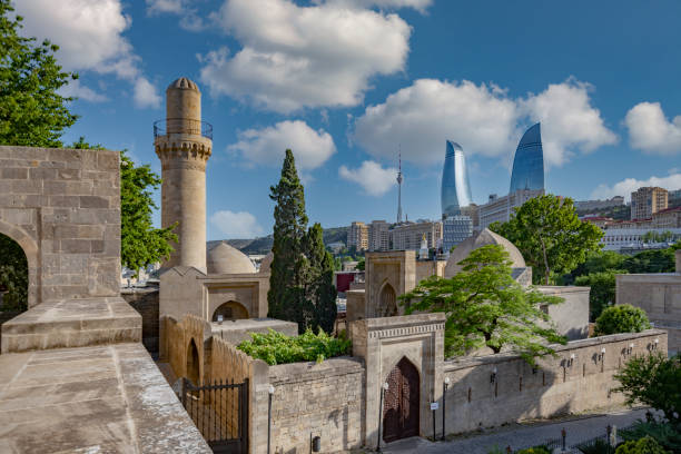 View of The Gilahli Mosque next to the Shirvanshah’s Palace( built in 15th century ) and also famous Flame Towers in the background at sunny day in Baku, Azerbaijan